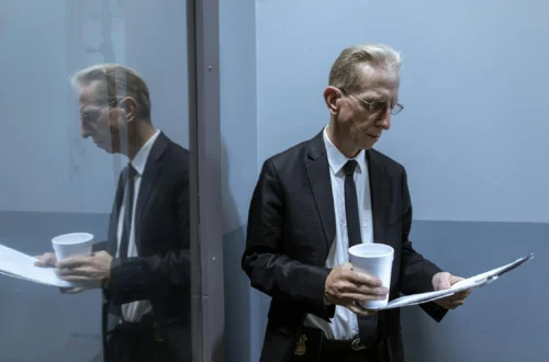 Man in Black Suit Holding White Ceramic Mug