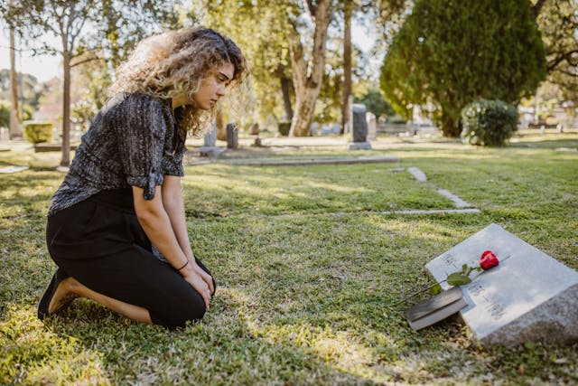 Women visit deceased family member at cemetery