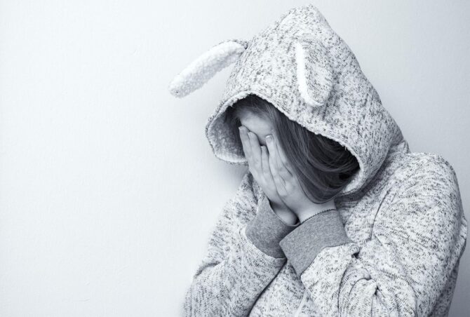 woman covering face victim of domestic violence