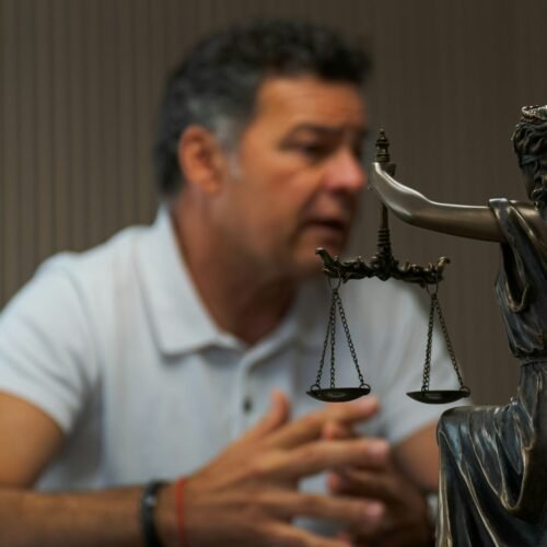 a-man-sitting-at-a-table-in-front-of-a-statue