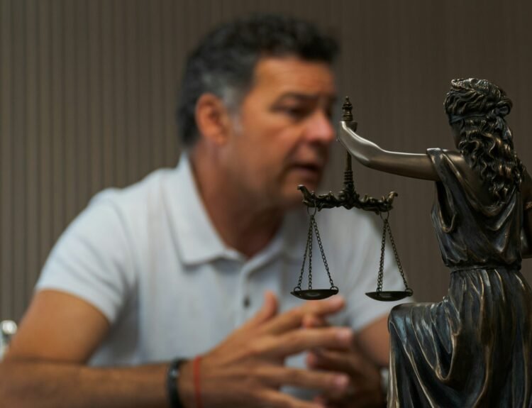a-man-sitting-at-a-table-in-front-of-a-statue